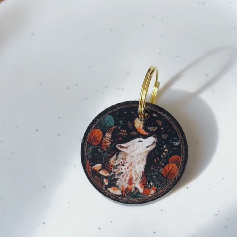 Présentation vidéo de la médaille pour chien 'Loup Mystique' en résine époxy. On voit la médaille briller sous la lumière, révélant ses détails artisanaux et ses reflets dorés. Texte affiché : Fait main en Touraine, Silencieuse et Durable.